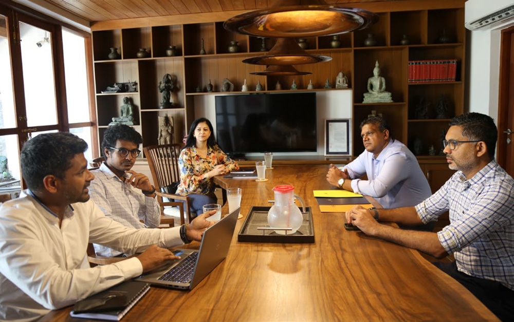 A group of Sri Lanka's Businessmen and woman hold a meeting in a traditional Sri Lankan boardroom.