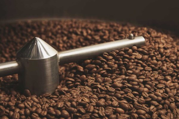 A close-up of coffee beans grinding in a coffee grinder, a scene from the video "Sri Lanka’s Coffee Comeback."