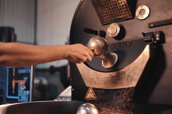 A man uses a coffee grinder to process coffee beans as part of a video on the revival of Sri Lanka's coffee industry.