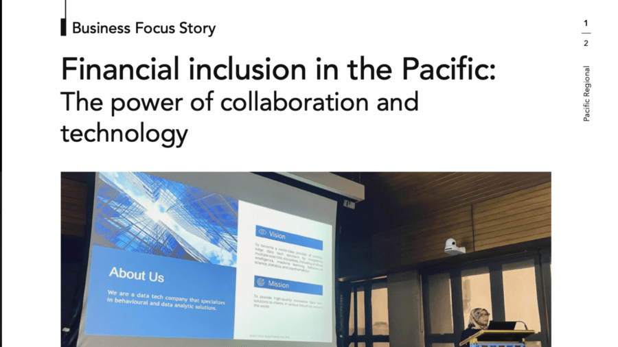 Presenter speaking beside a projected slide about data and analytics at a financial inclusion event.