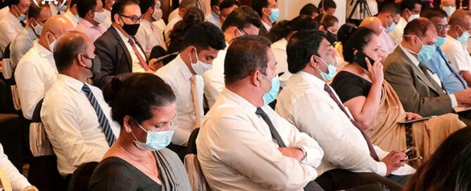Masked attendees seated at an indoor business event in Sri Lanka during the COVID-19 pandemic.