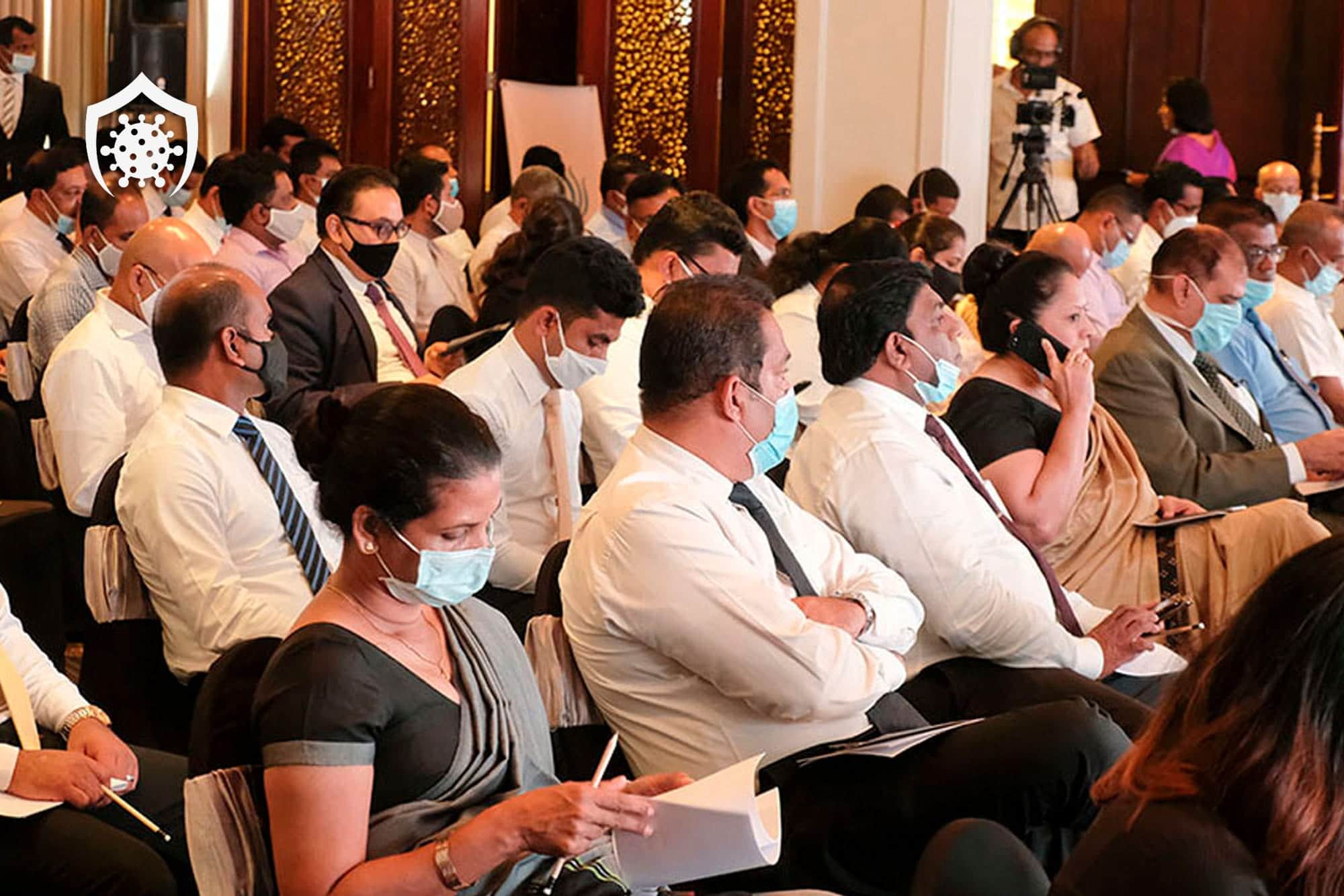 Masked attendees seated at an indoor business event in Sri Lanka during the COVID-19 pandemic.