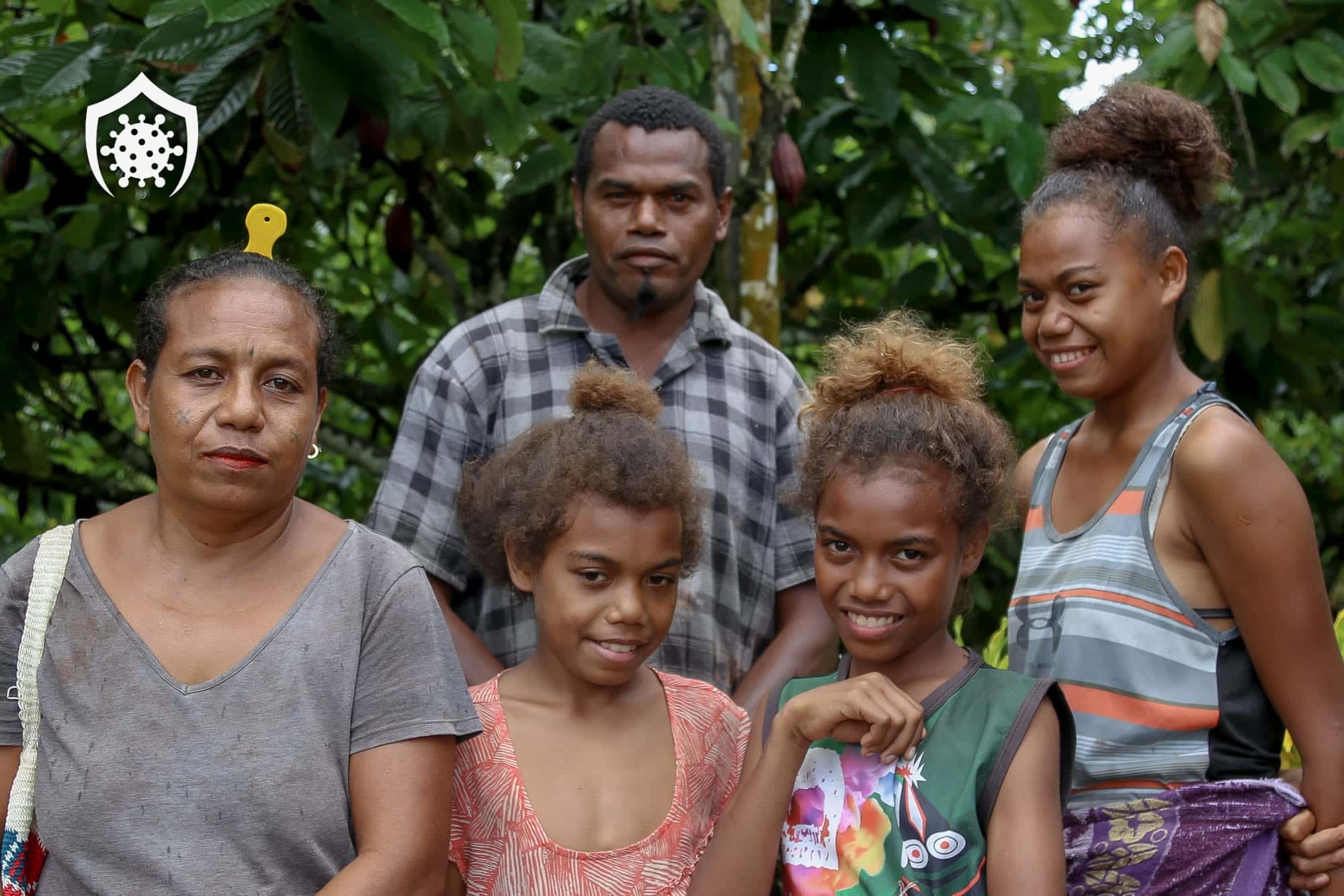 Family group standing outdoors with a COVID-19 shield icon overlay.