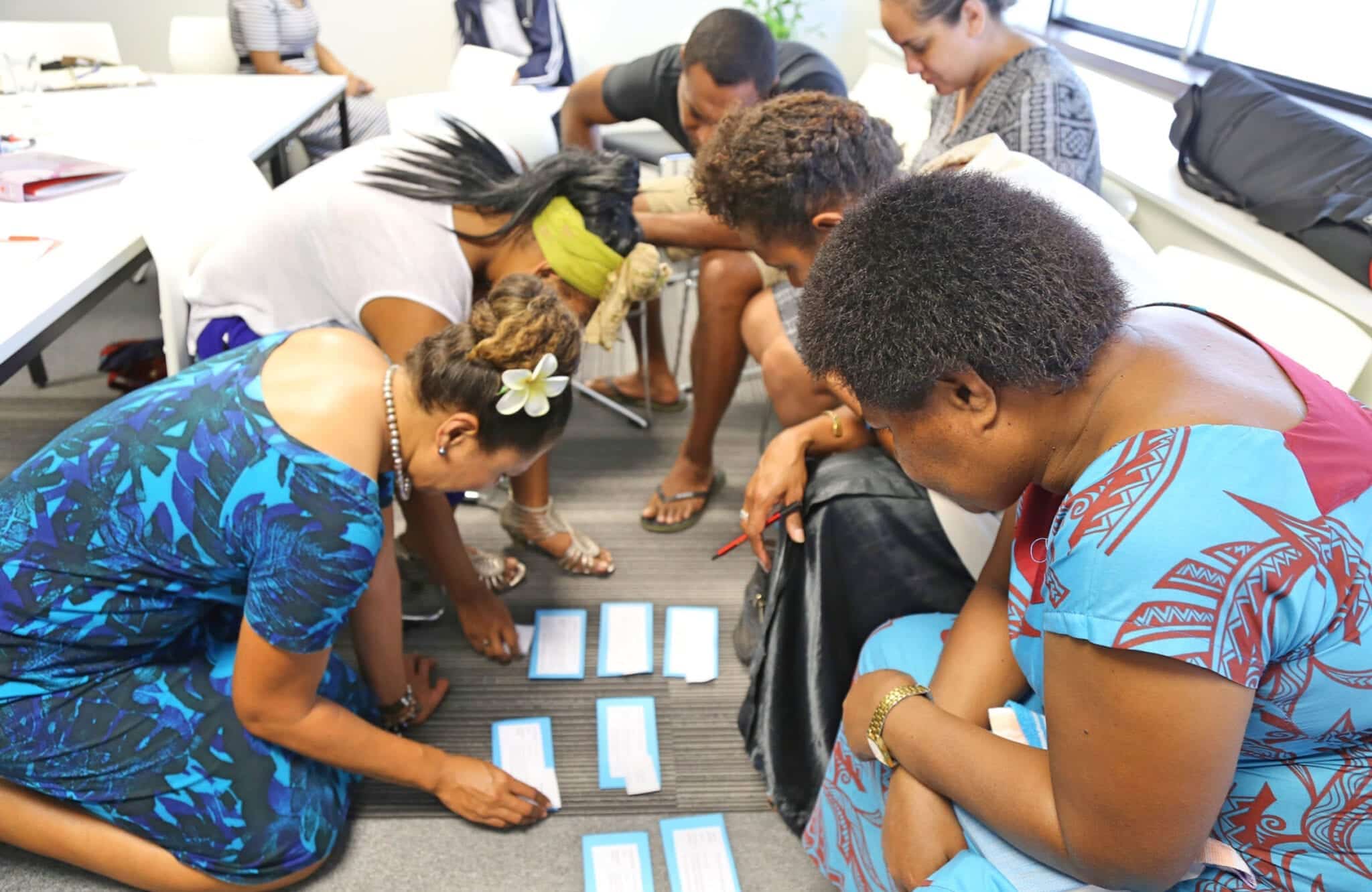 Workshop participants arranging cards during a Fiji Enterprise Engine training activity.