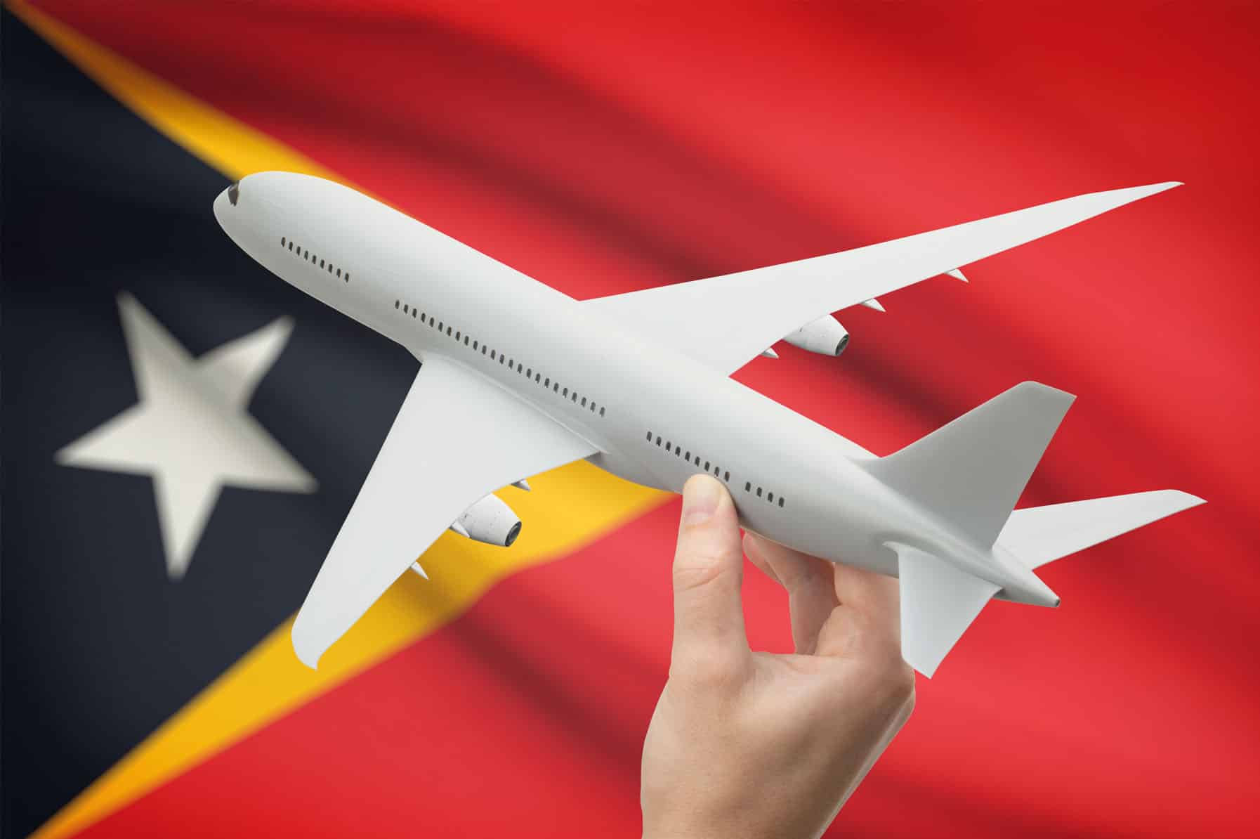 toy passenger aircraft is help over on the Timorese flag, representing Qantas' new commercial flights to Dili, Timor-Leste.