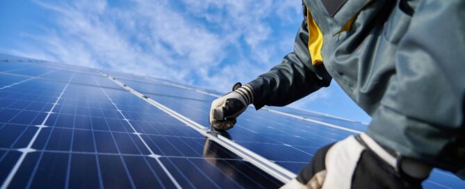 Male worker repairing photovoltaic solar panel.