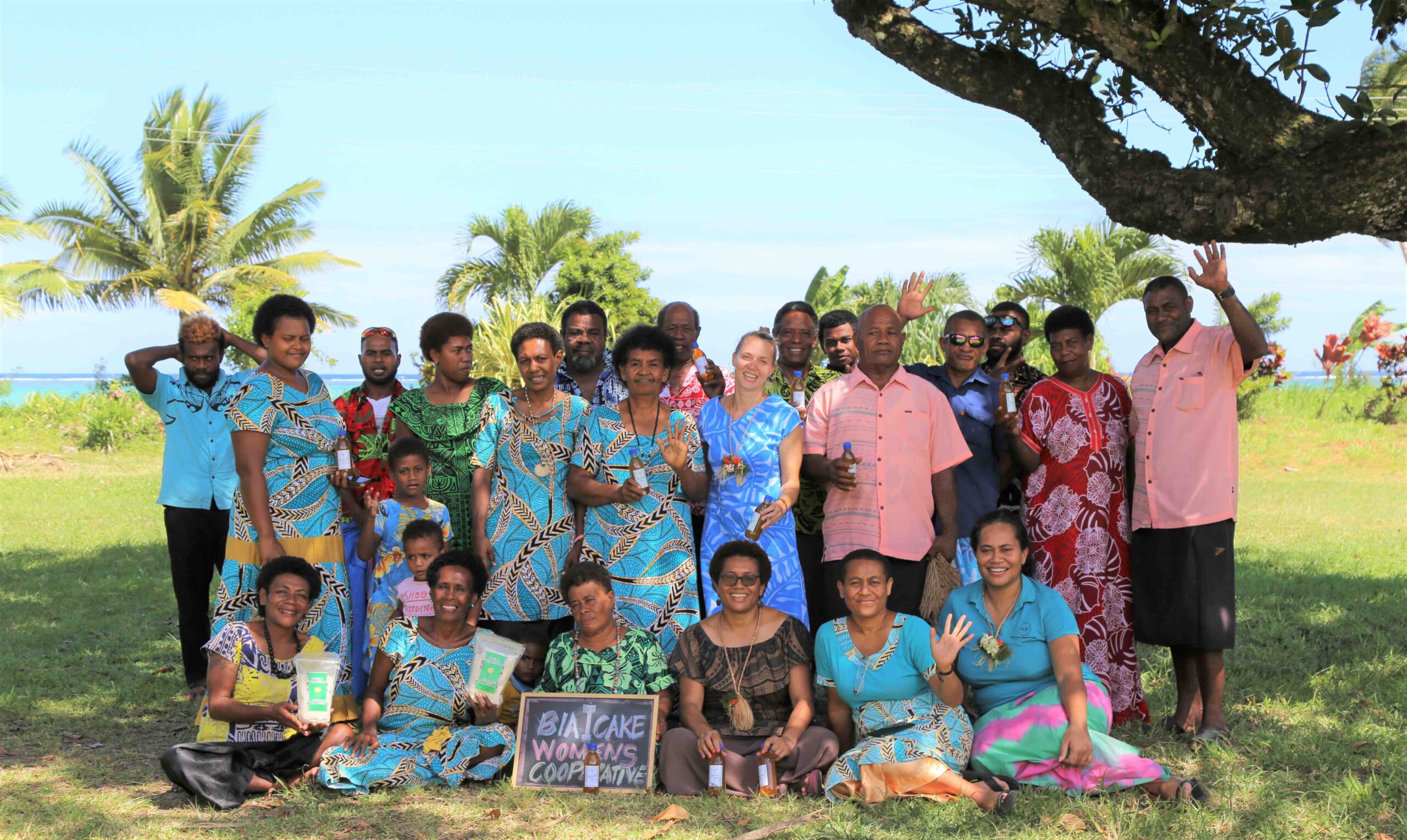 A group photo of the first secretary with members of the Biaicake Women's Cooperative, all smiling together.