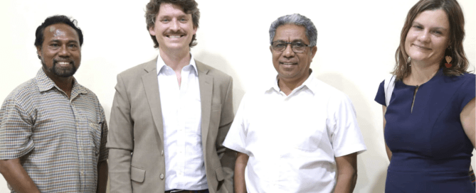 Four representatives standing together during an introductory meeting in Timor-Leste.
