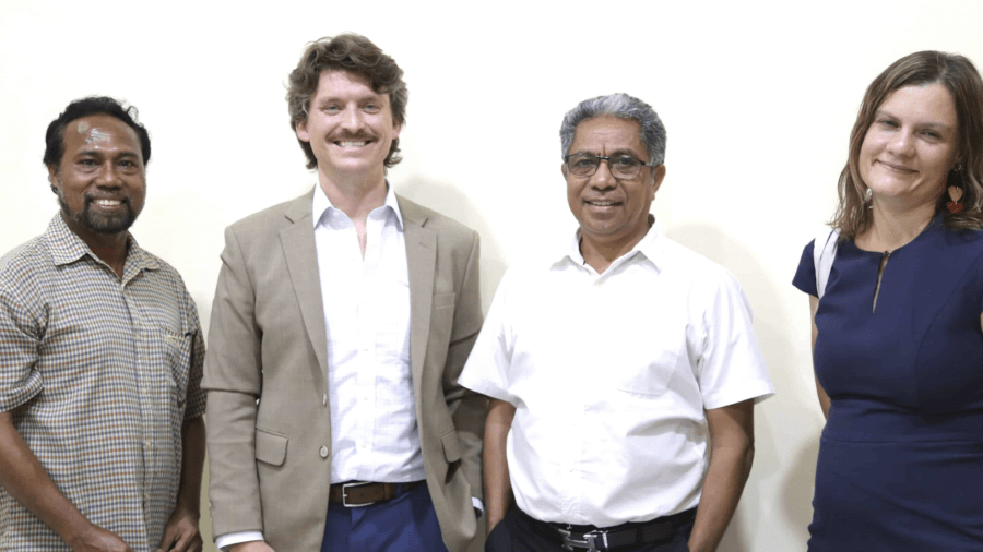 Four representatives standing together during an introductory meeting in Timor-Leste.